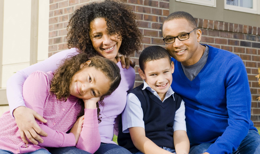 Family close together hugging and smiling