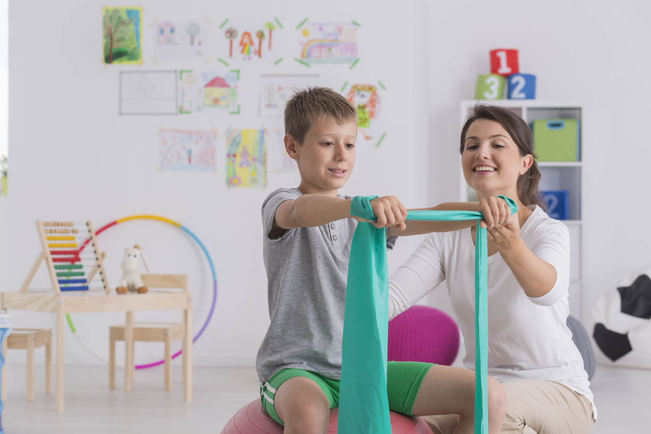 Related service staff member woman works with elementary age boy