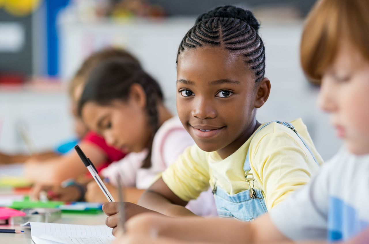 Elementary age girl in writing class smiling